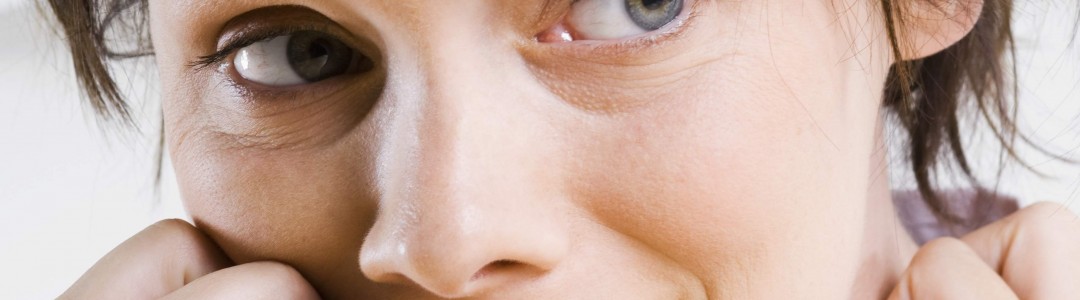 young woman with short messy hair, biting nails looking terrified